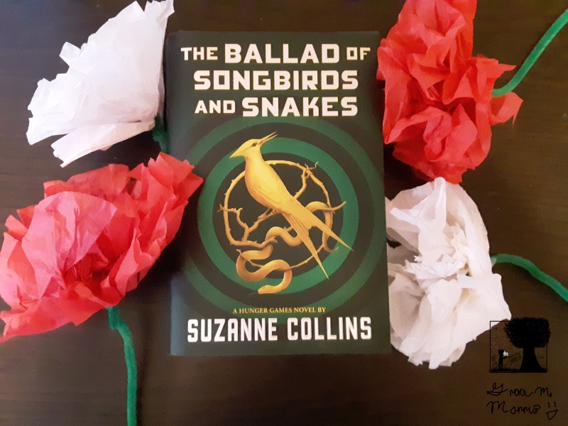 "The Ballad of Songbirds and Snakes" with paper flowers.